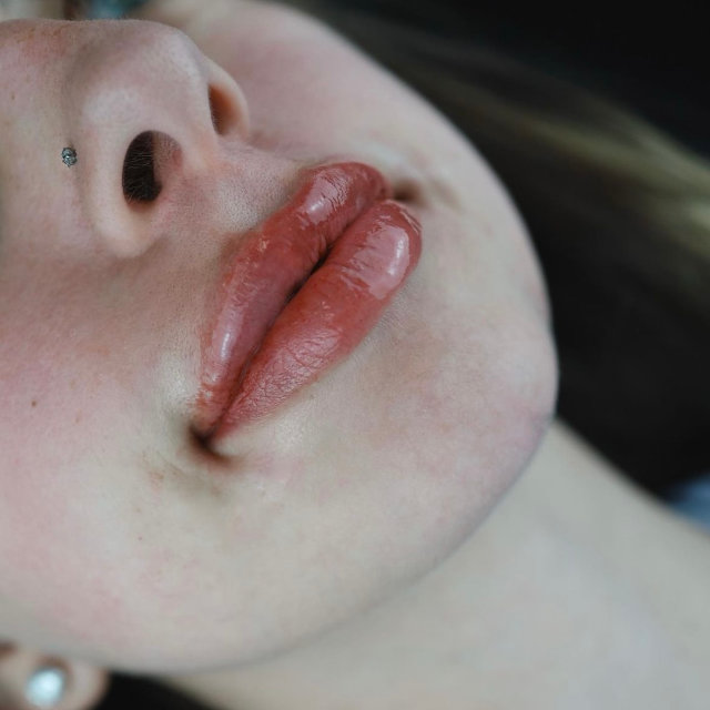 Close-up of a woman's lower face showing her nose, lips, and chin, with a focus on her lips which are slightly parted.
